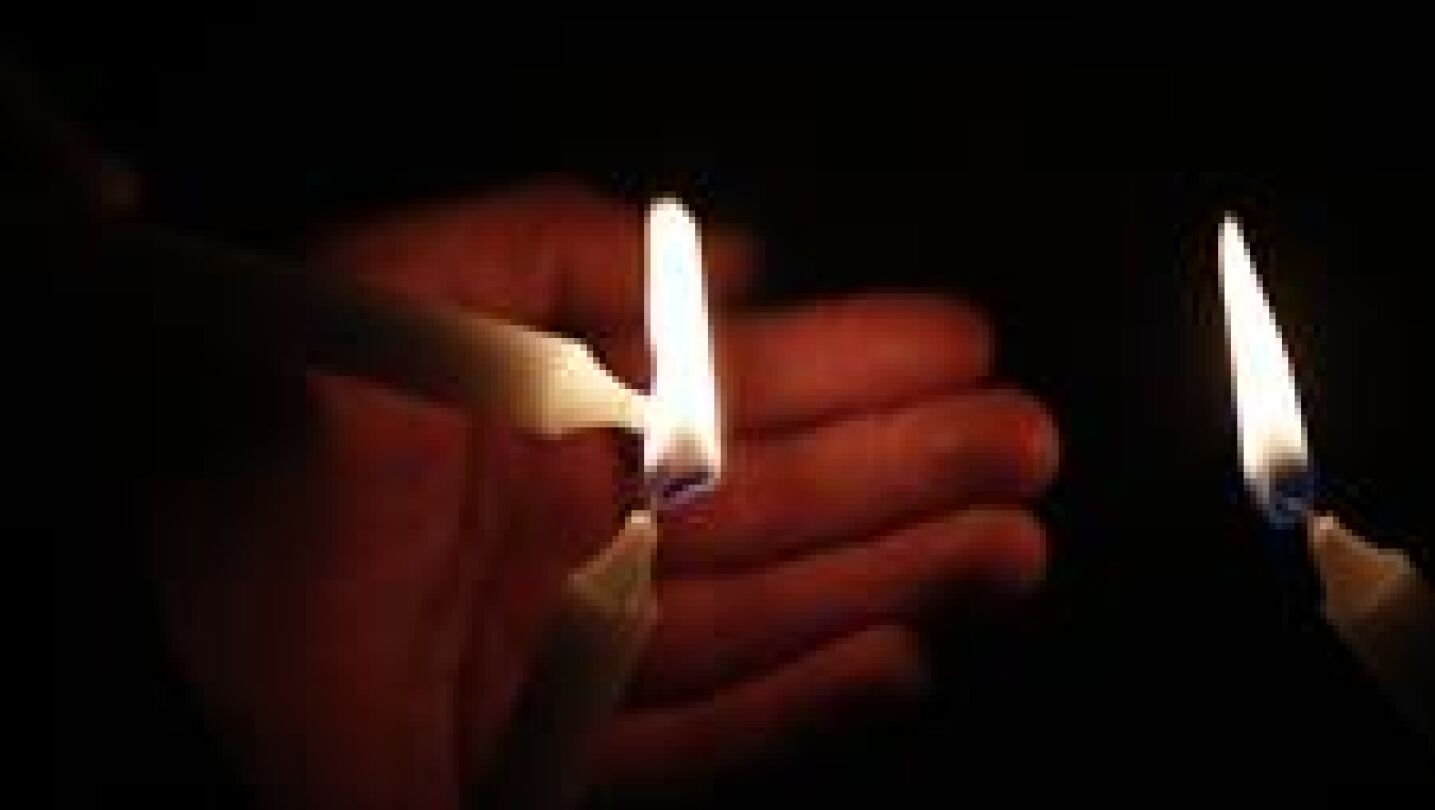 Una persona enciende velas al equipo de periodistas del diario El Comercio