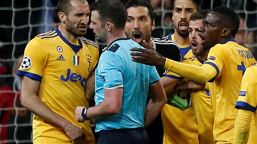 El colegiado Michael Oliver, acosado por los jugadores de la Juventus