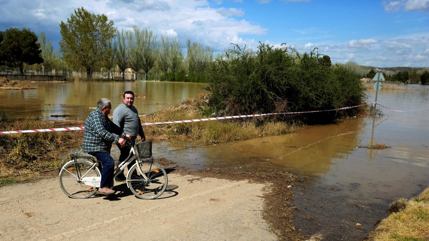Vecinos de la localidad zaragozana de Monzalbarba contemplan su vivienda, aislada por la crecida del r&iacute;o Ebro