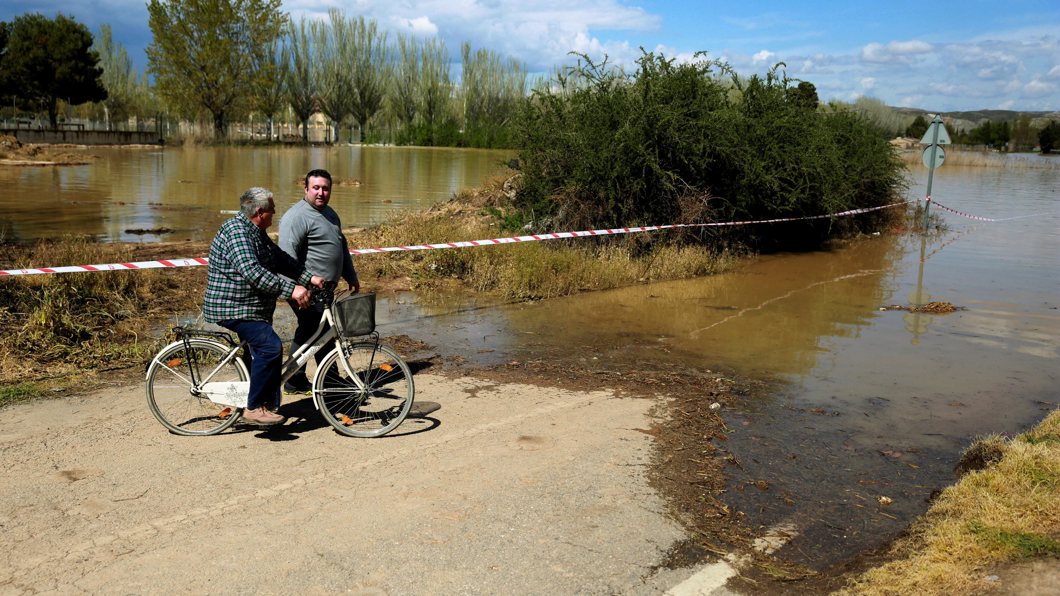 Vecinos de la localidad zaragozana de Monzalbarba contemplan su vivienda, aislada por la crecida del río Ebro