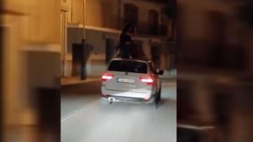 Varias personas bailando sobre un coche en circulación