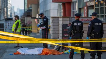 Oficiales de la policía de Toronto vigilan frente al cuerpo de una de las víctimas