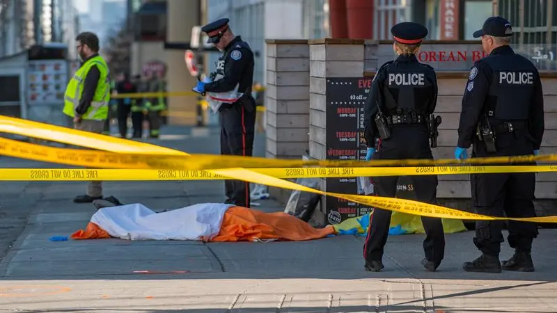 Oficiales de la policía de Toronto vigilan frente al cuerpo de una de las víctimas