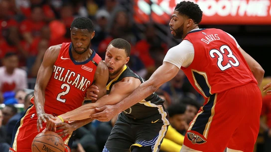 Curry intenta robar el balón entre Holiday y Davis Curry intenta robar el balón entre Holiday y Davis