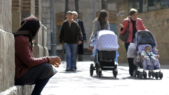 Una mujer pide lismona a las puertas de una iglesia Una mujer pide lismona a las puertas de una iglesia