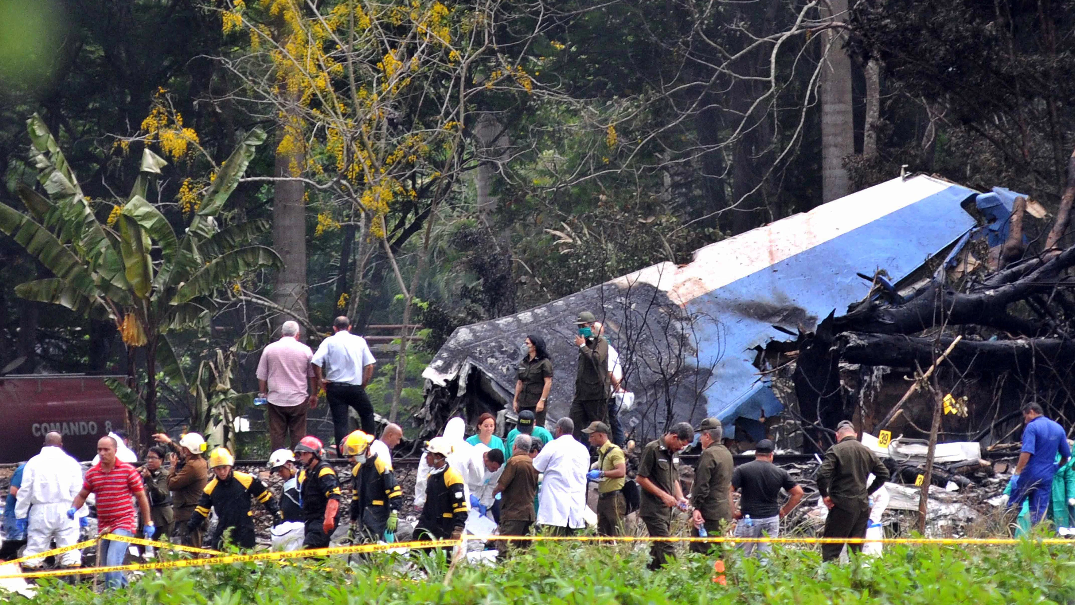 olicías y militares trabajan entre los restos del avión Boeing-737