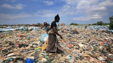 Imagen de archivo de una mujer que rebusca botellas de plástico en el basurero de Akouedo, en Abiyán, en Costa del Marfil