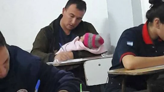 Hugo Vezzi con su bebé Bianca en brazos mientras se examina Hugo Vezzi con su bebé Bianca en brazos mientras se examina