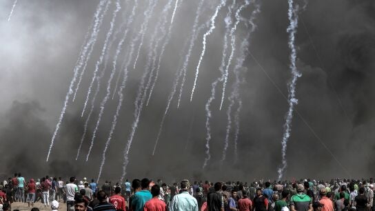 Cientos de palestinos observan las c&aacute;psulas de gases lacrim&oacute;genos lanzadas por Israel