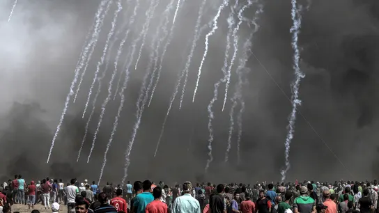 Cientos de palestinos observan las cápsulas de gases lacrimógenos lanzadas por Israel Cientos de palestinos observan las cápsulas de gases lacrimógenos lanzadas por Israel