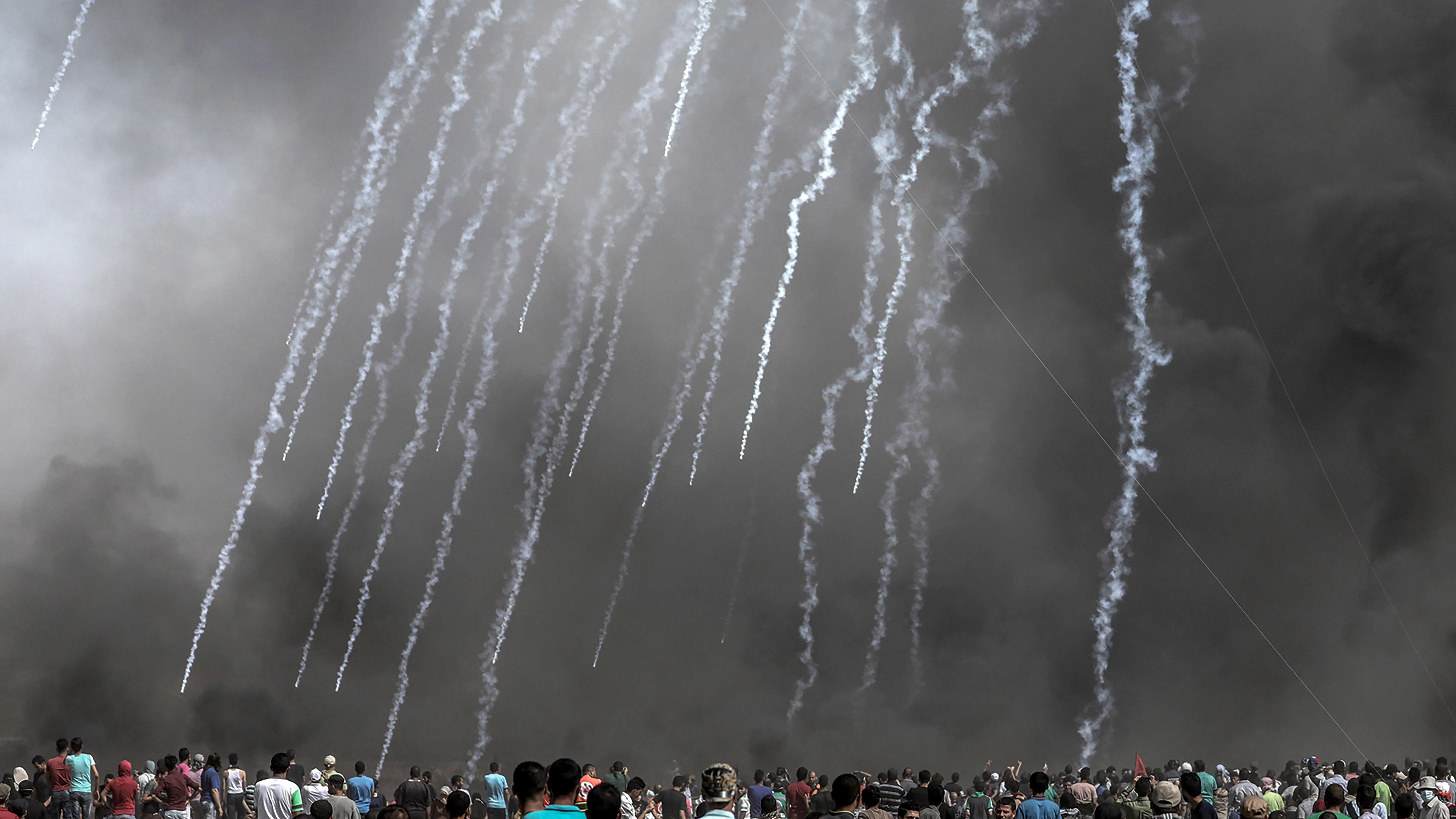 Cientos de palestinos observan las cápsulas de gases lacrimógenos lanzadas por Israel