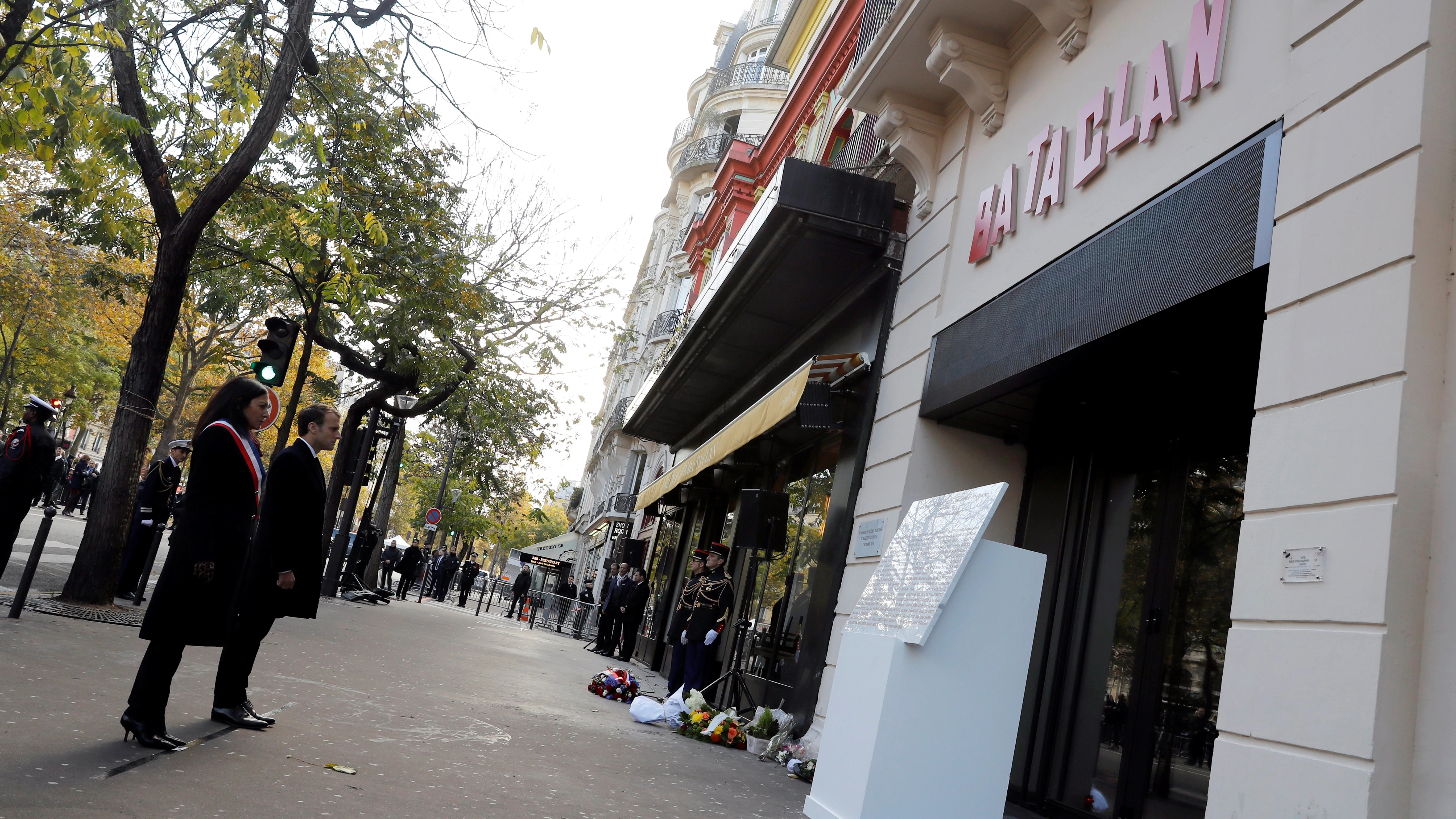 El presidente galo, Emmanuel Macron (2º izq), y la alcaldesa de París, Anne Hidalgo (izq), guardan silencio ante una placa conmemorativa colocada a las puertas de la sala de conciertos Bataclan