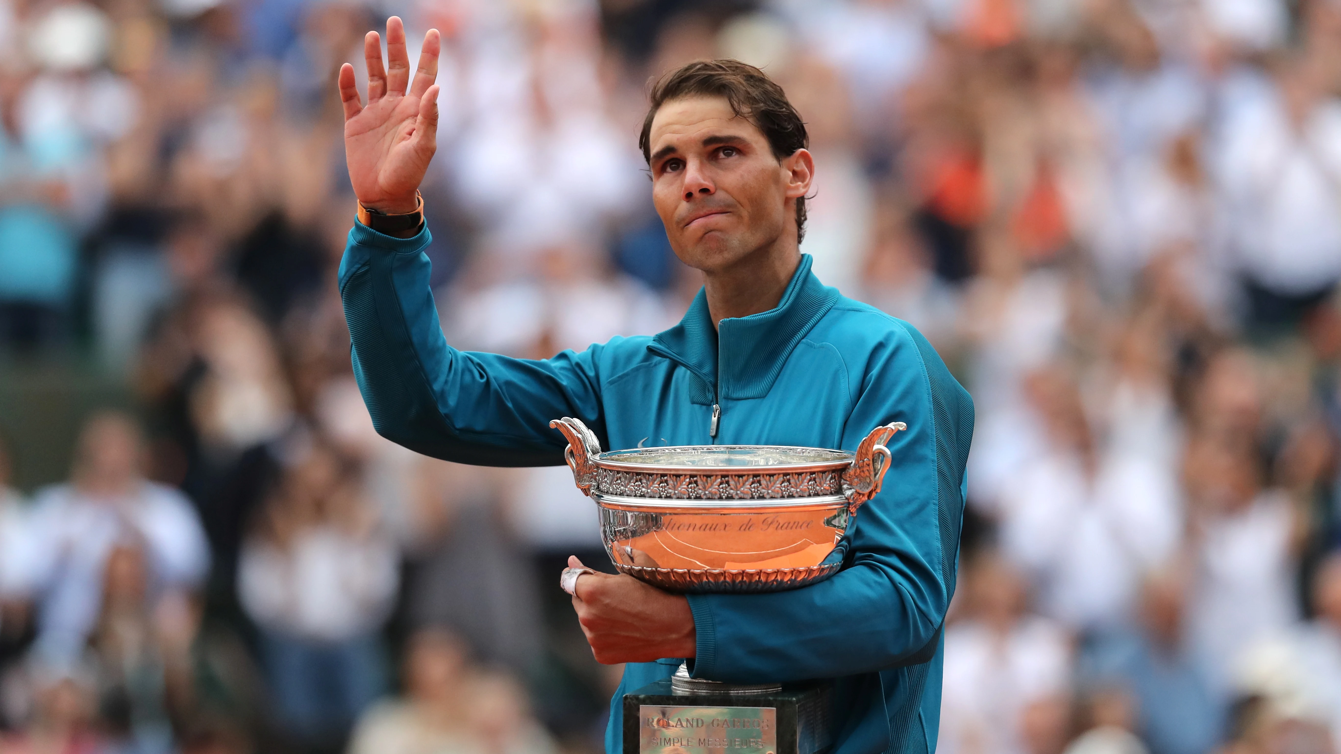 Rafa Nadal saluda al público con el trofeo de Roland Garros