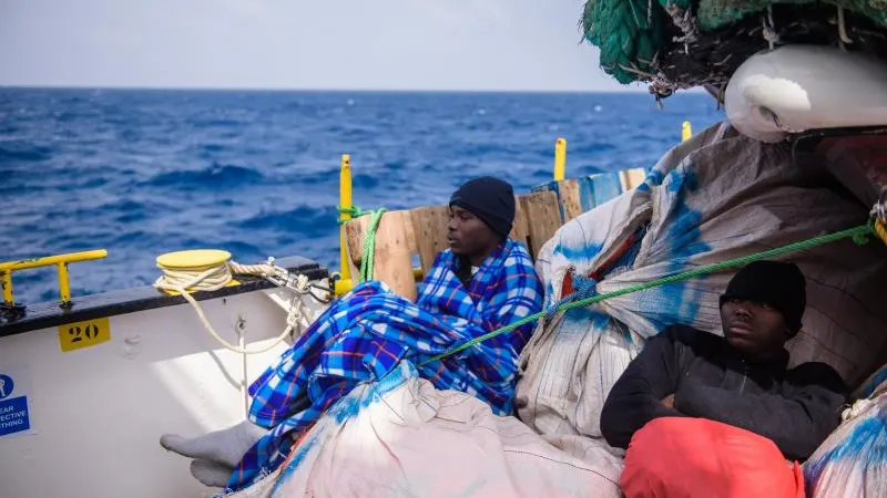 Inmigrantes descansan a bordo de un barco después de ser rescatados en el Mediterráneo