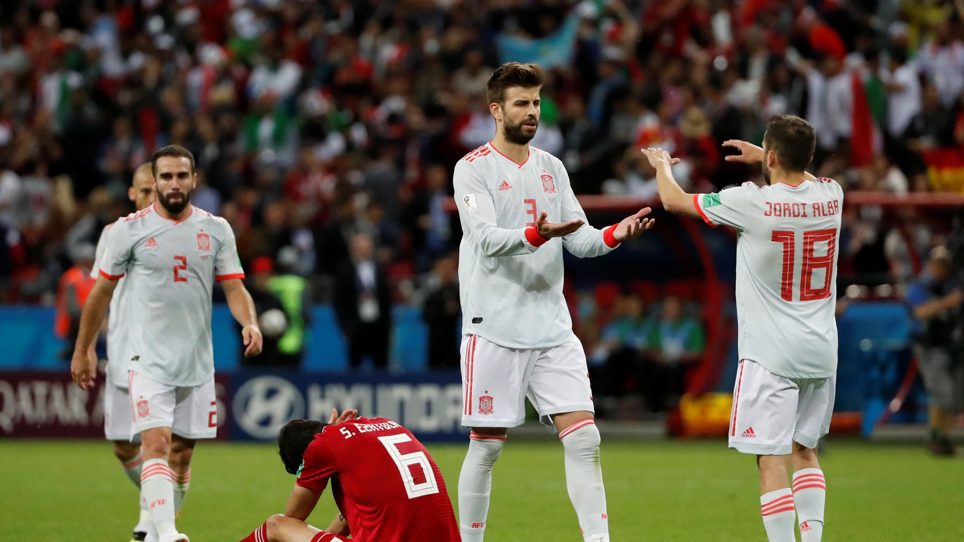 Piqué se saluda a Jordi Alba durante el partido contra Irán