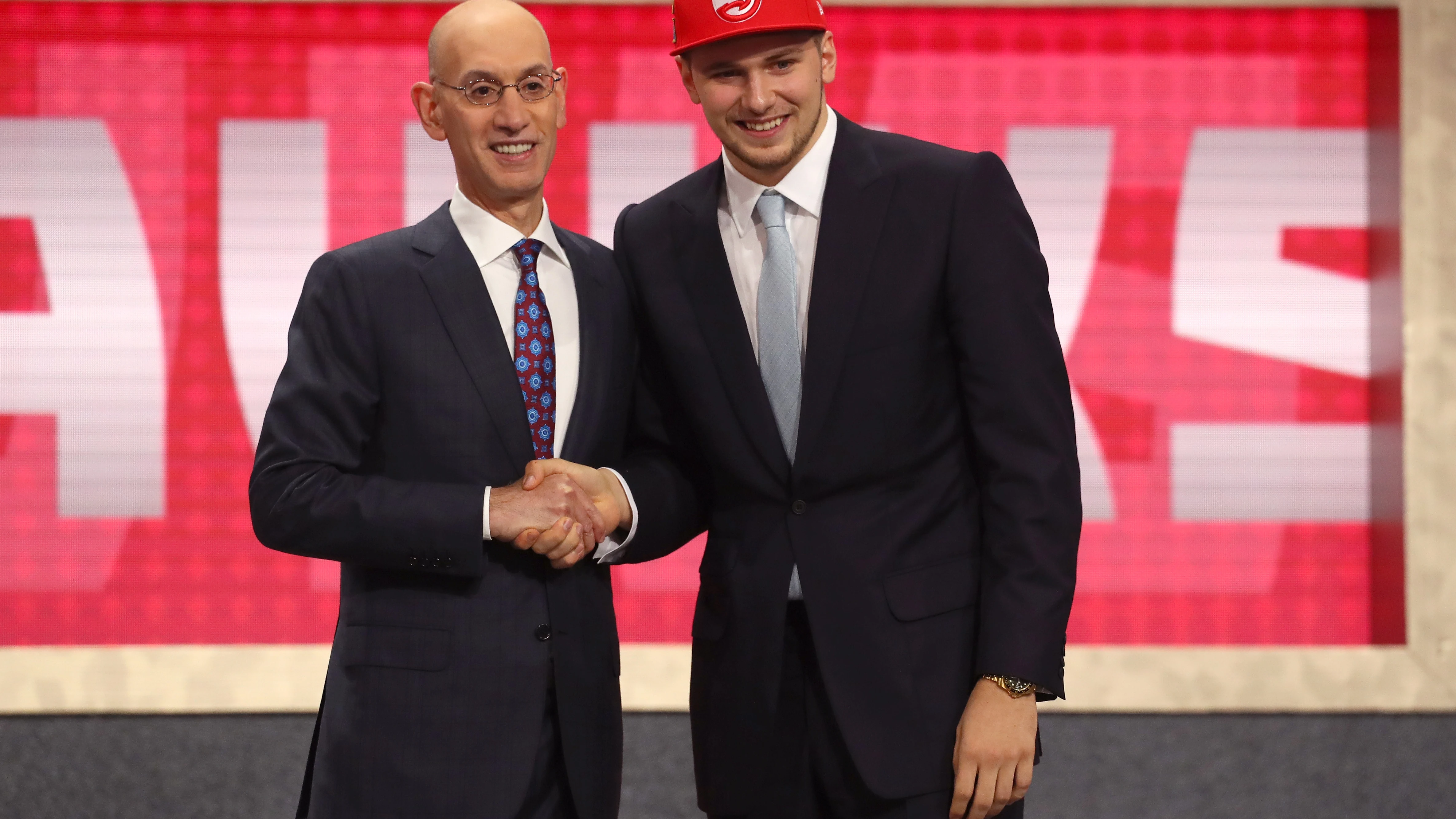 Luka Doncic y Adam Silver se estrechan la mano en la noche del Draft