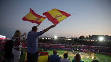 Dos personas agitan banderas al paso de los atletas españoles durante la inauguración de los XVIII Juegos Mediterráneos