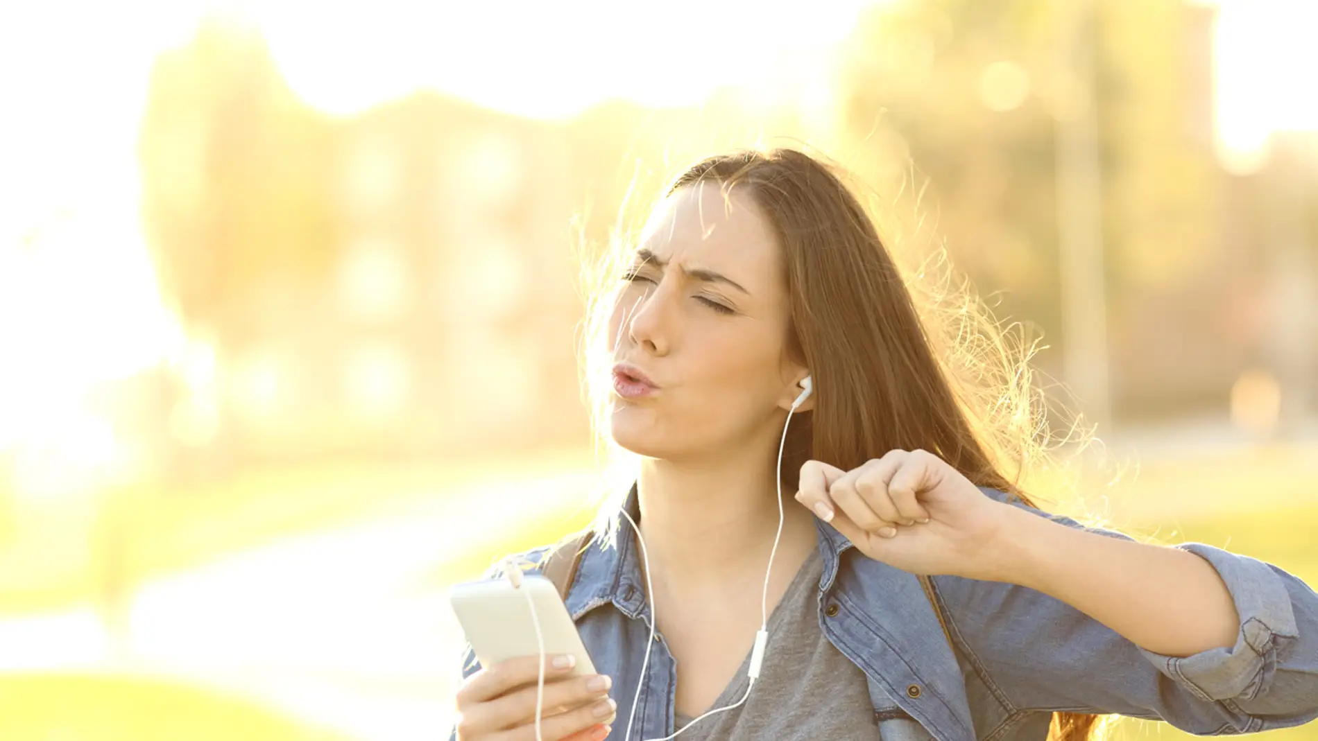 Chica disfruta escuchando música en el móvil