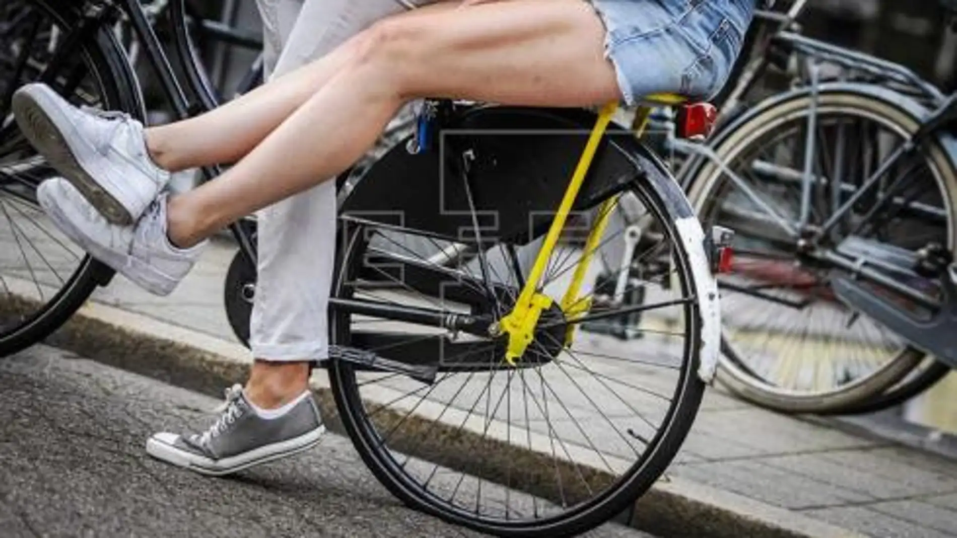 Moverse en bici y cobrar por ello, nueva idea de Holanda contra los coches Dos personas montan en bicicleta por las calles de Amsterdam 