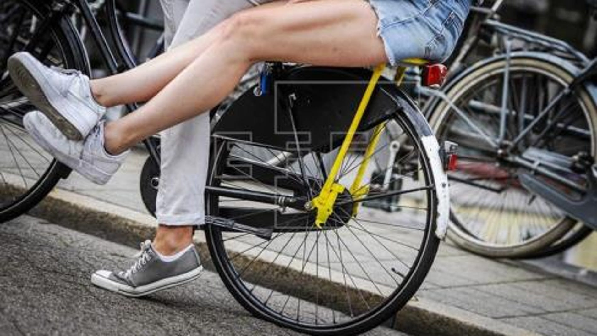 Moverse en bici y cobrar por ello, nueva idea de Holanda contra los coches Dos personas montan en bicicleta por las calles de Amsterdam