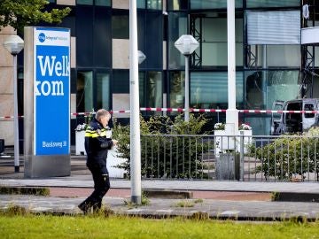 Un oficial de la policía pasa delante de la furgoneta que se empotró contra la sede del diario 'De Telegraaf' en Ámsterdam Un oficial de la policía pasa delante de la furgoneta que se empotró contra la sede del diario 'De Telegraaf' en Ámsterdam