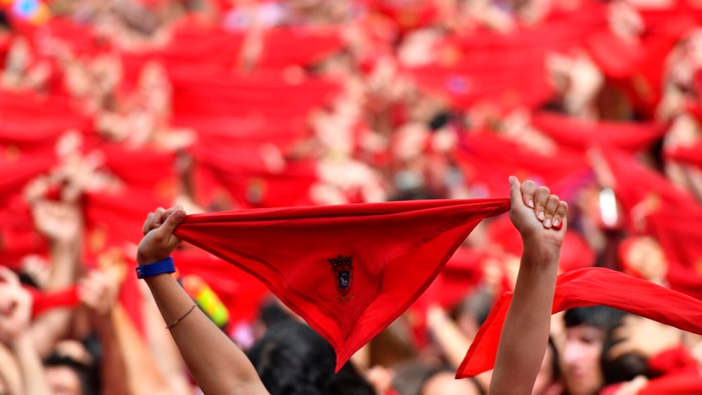 Cientos de personas festejan en la Plaza del Castillo de Pamplona, con sus pa&ntilde;uelos rojos alzados