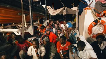 Varios inmigrantes descansan a bordo del buque 'Lifeline'