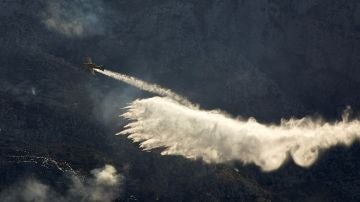 Una avioneta trabaja en las labores de extinción del incendio forestal declarado en el Montgó
