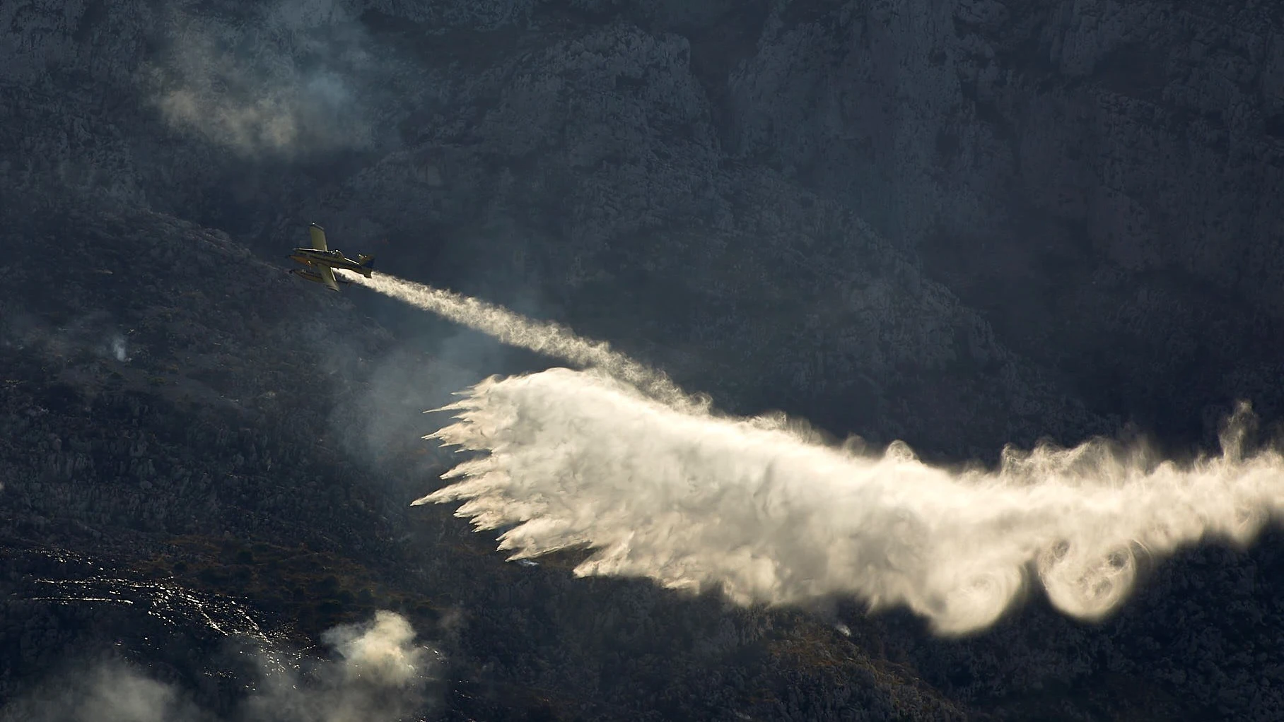 Una avioneta trabaja en las labores de extinción del incendio forestal declarado en el Montgó