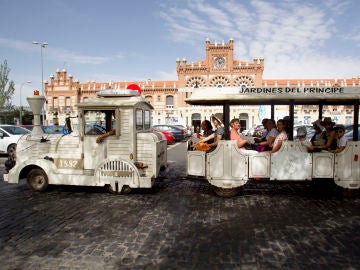 Grupo de turistas recorre la ciudad en un tren turístico Grupo de turistas recorre la ciudad en un tren turístico