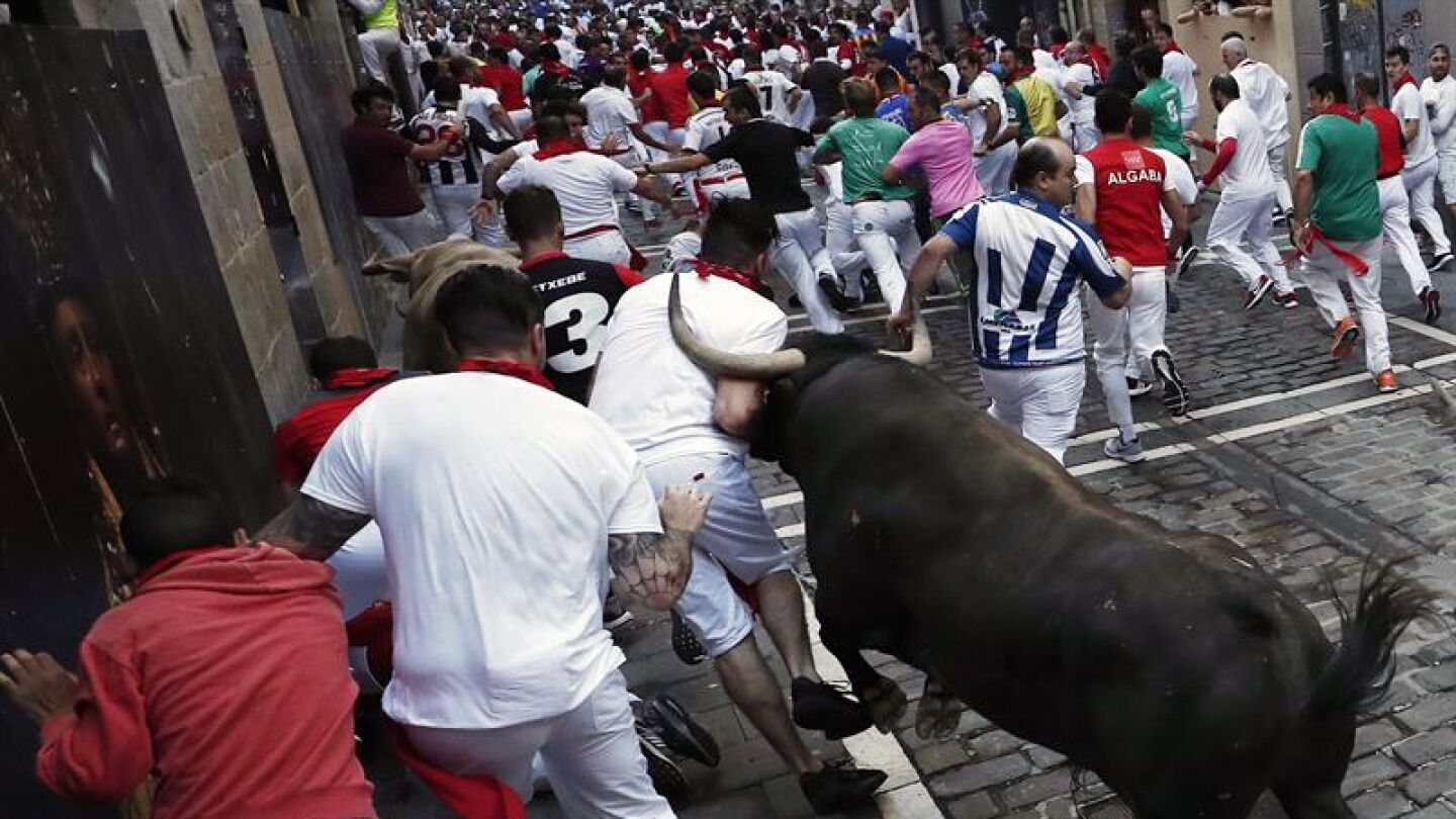 Los toros de la ganader&iacute;a gaditana de N&uacute;&ntilde;ez del Cuvillo enfilan junto a mansos y corredores la curva de Mercaderes con la calle Estafeta.