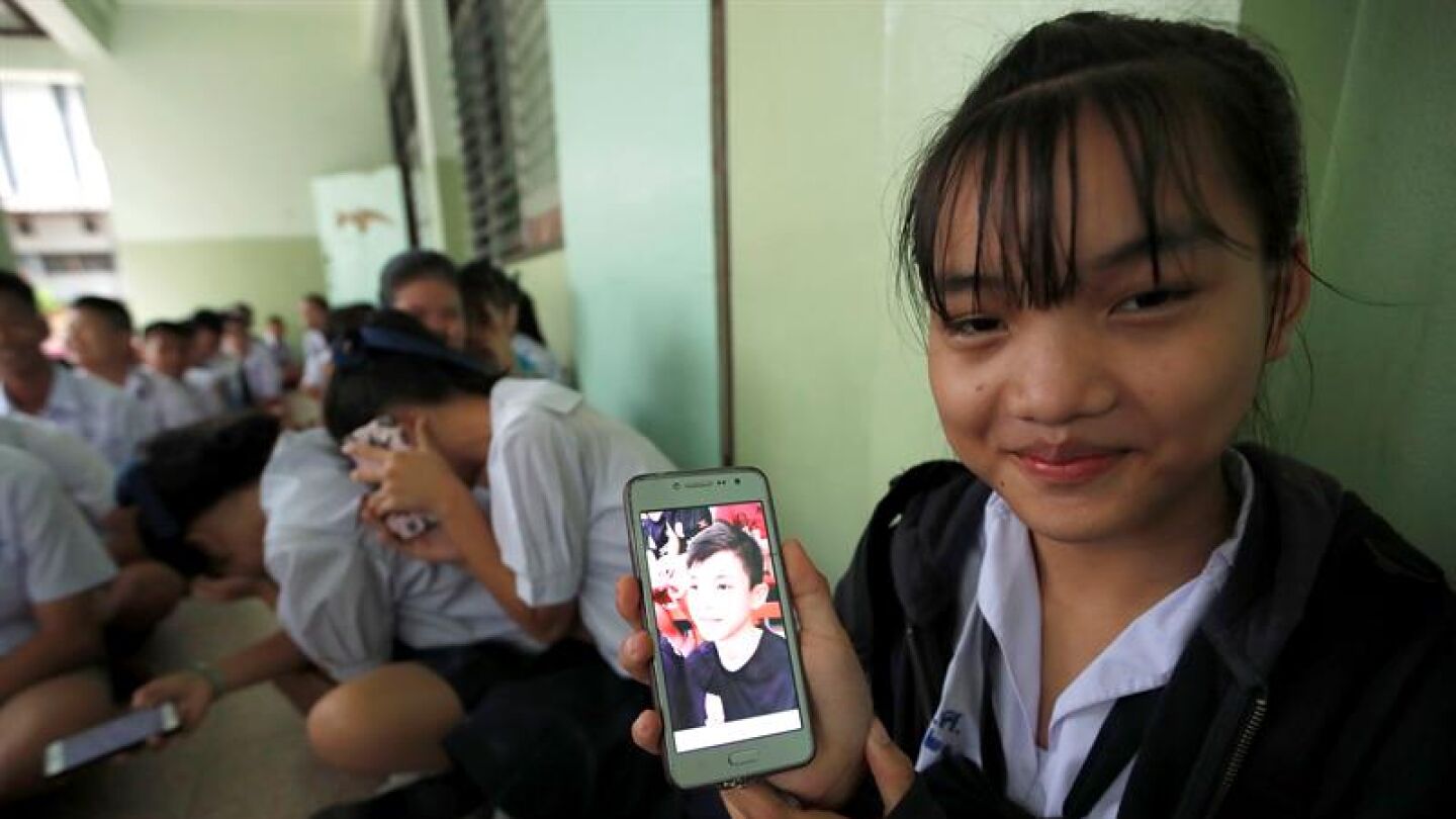 Una estudiante tailandesa muestra una fotograf&iacute;a de su compa&ntilde;ero de clase