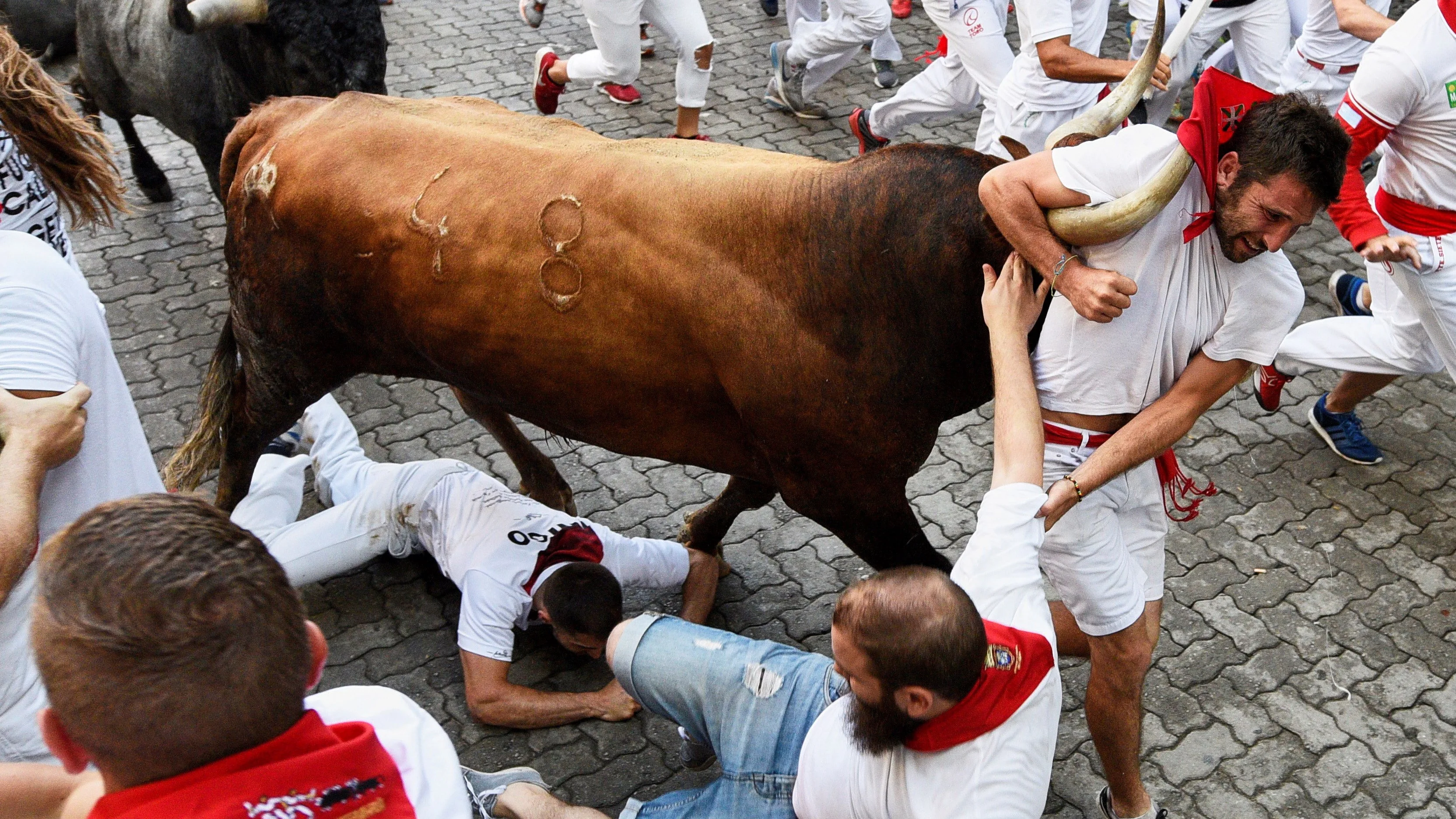 Último encierro de San Fermín 2018: las impactantes imágenes que muestran a un mozo enganchado al cuerno de un toro por su pañuelo