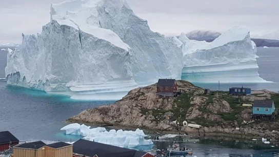 Vista general de un iceberg situado al lado de la aldea de Innaarsuit Vista general de un iceberg situado al lado de la aldea de Innaarsuit