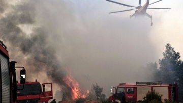 Un helicóptero intenta extinguir un fuego en Verori, cerca de la ciudad de Loutraki (Grecia