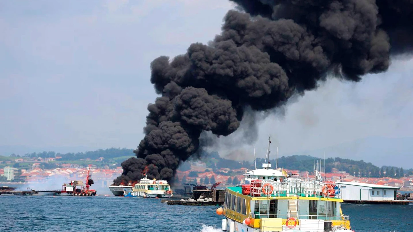 Columna de humo negro provocada por el incendio de un catamarán turístico. Columna de humo negro provocada por el incendio de un catamarán.