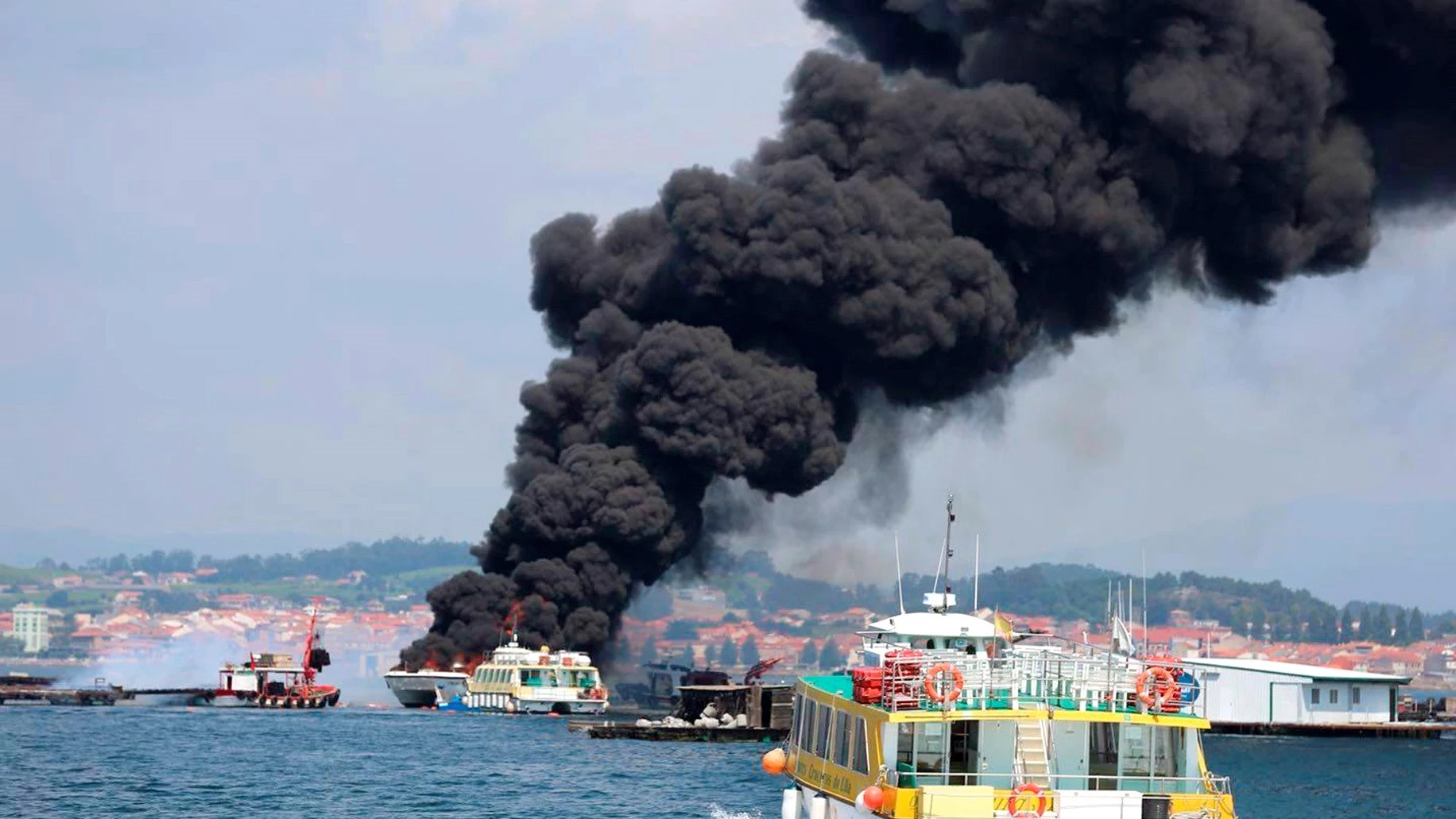 Columna de humo negro provocada por el incendio de un catamarán.