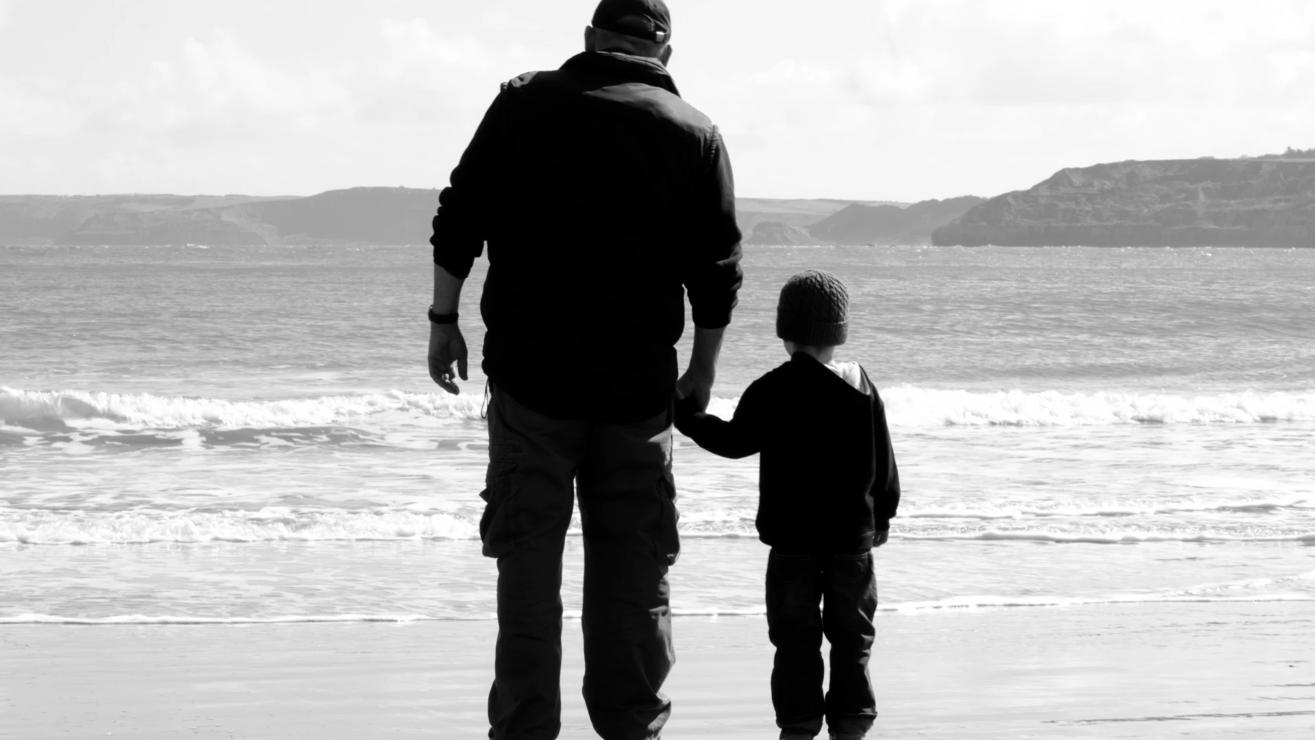 Imagen de un abuelo con su nieto en la playa