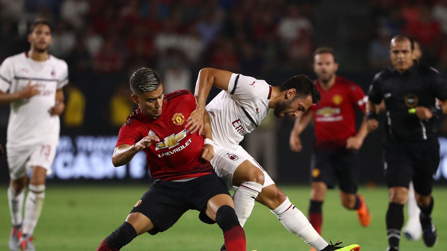 Hakan Calhanoglu y Andreas Pereira pelean por un balón