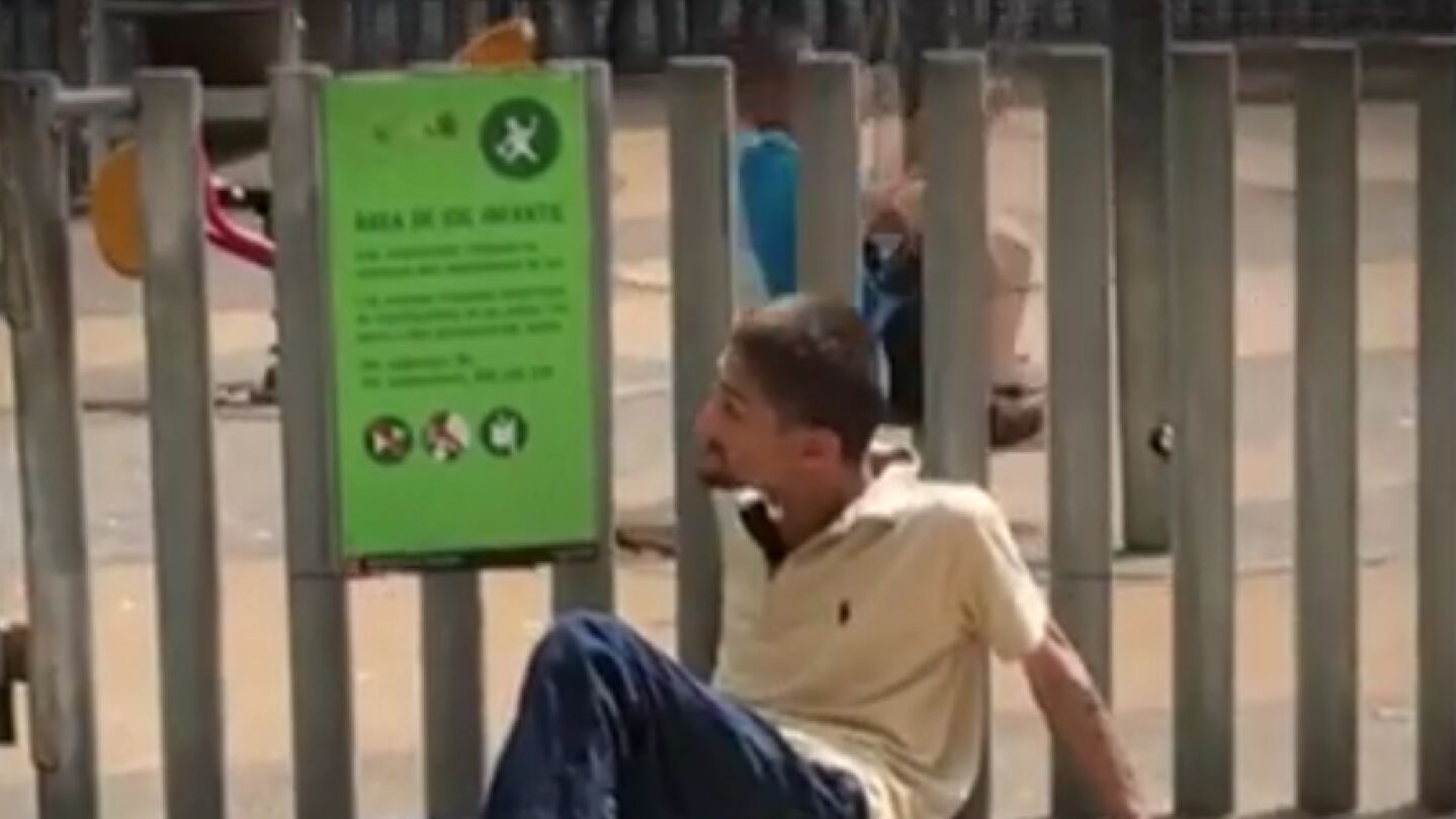 Un toxicomano al lado de un ni&ntilde;o jugando