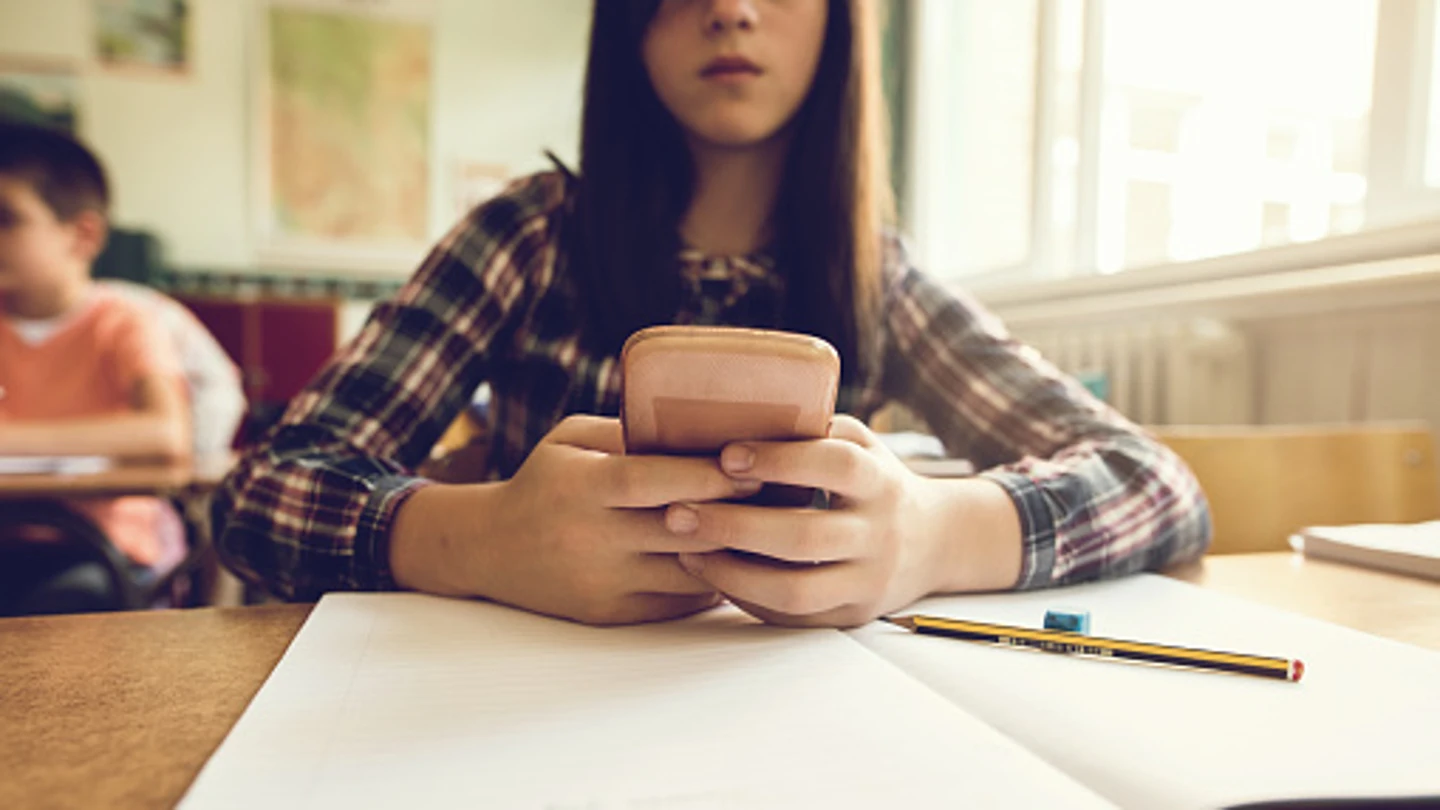 Una estudiante con un móvil durante una clase Una estudiante con un móvil durante una clase