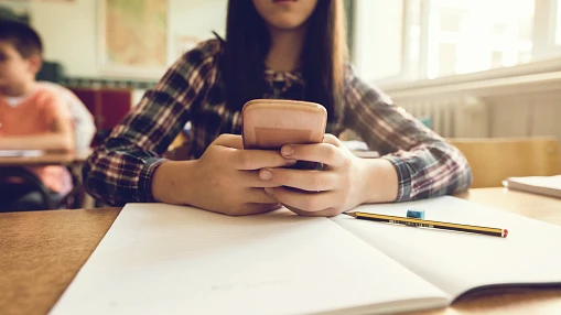 Una estudiante con un móvil durante una clase