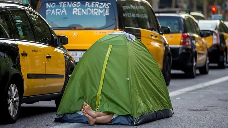 Un taxista acampa junto a la hilera de taxis en el centro de Barcelona