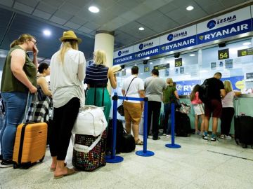 Pasajeros de Ryanair hacen cola en el aeropuerto Pasajeros de Ryanair hacen cola en el aeropuerto