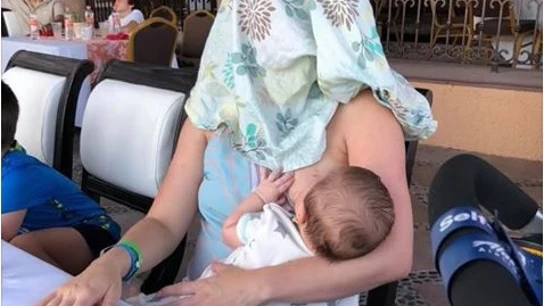 Mujer cubierta mientras amamanta a su hijo Mujer cubierta mientras amamanta a su hijo