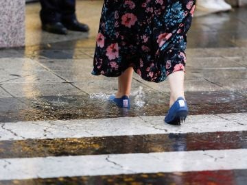 Una mujer cruza por un paso de peatones bajo una fuerte tormenta (Archivo) Una mujer cruza por un paso de peatones bajo una fuerte tormenta (Archivo)