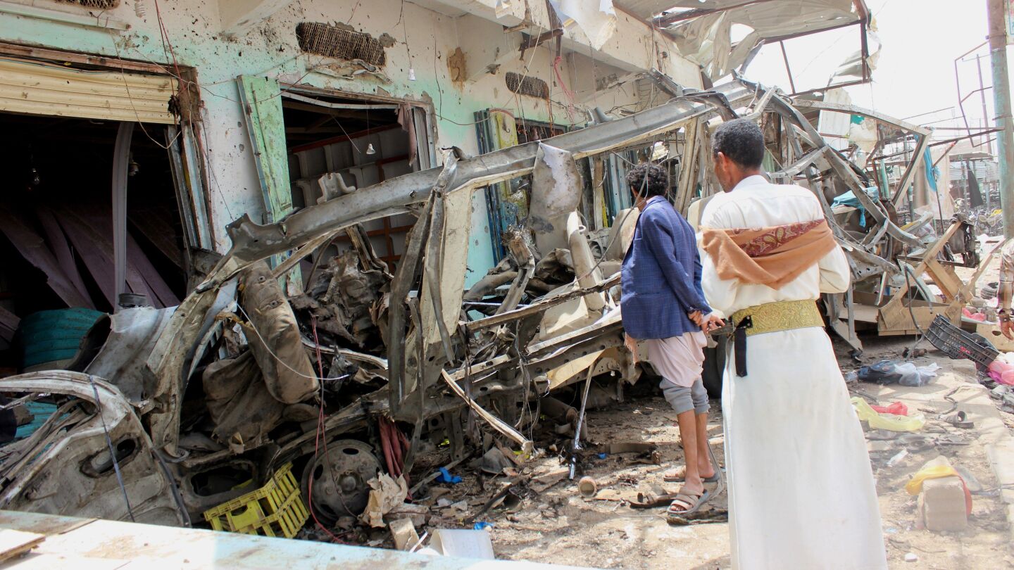 Varios hombres inspeccionan la escena de un ataque a&eacute;reo perpetrado por la coalici&oacute;n lidera por Arabia Saud&iacute;, despu&eacute;s del bombardeo a un autob&uacute;s con ni&ntilde;os que caus&oacute; 50 muertos y 77 heridos, en Sadaa (Yemen)