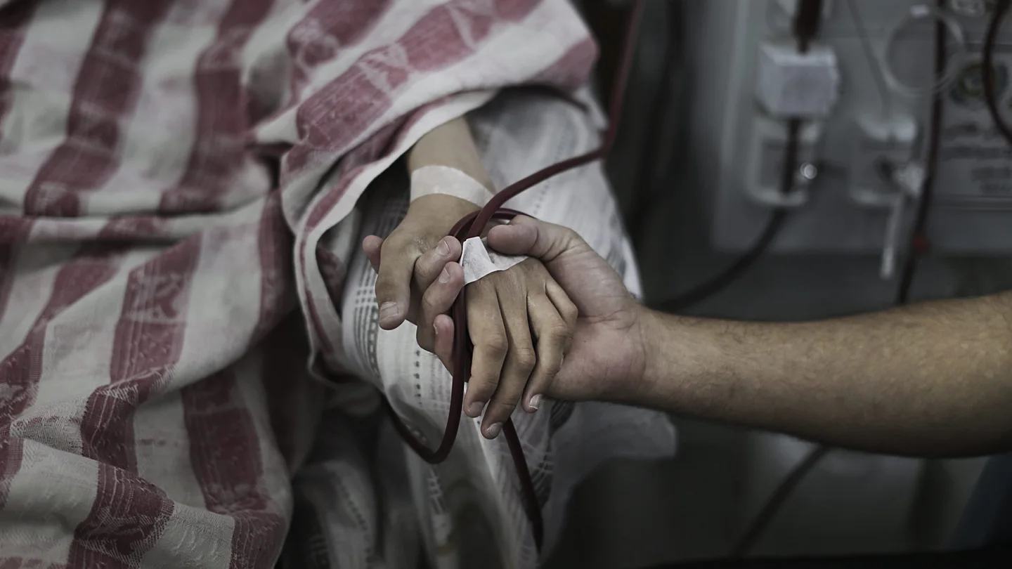 Un paciente palestino es consolado mientras recibe tratamiento en el área de diálisis del hospital al-Shifa, en Gaza Un paciente palestino es consolado mientras recibe tratamiento en el área de diálisis del hospital al-Shifa, en Gaza