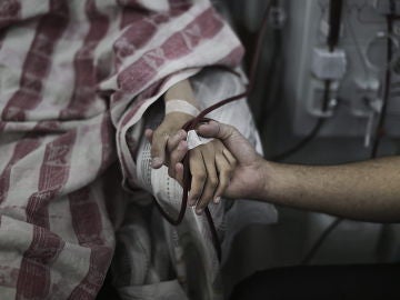 Un paciente palestino es consolado mientras recibe tratamiento en el área de diálisis del hospital al-Shifa, en Gaza Un paciente palestino es consolado mientras recibe tratamiento en el área de diálisis del hospital al-Shifa, en Gaza
