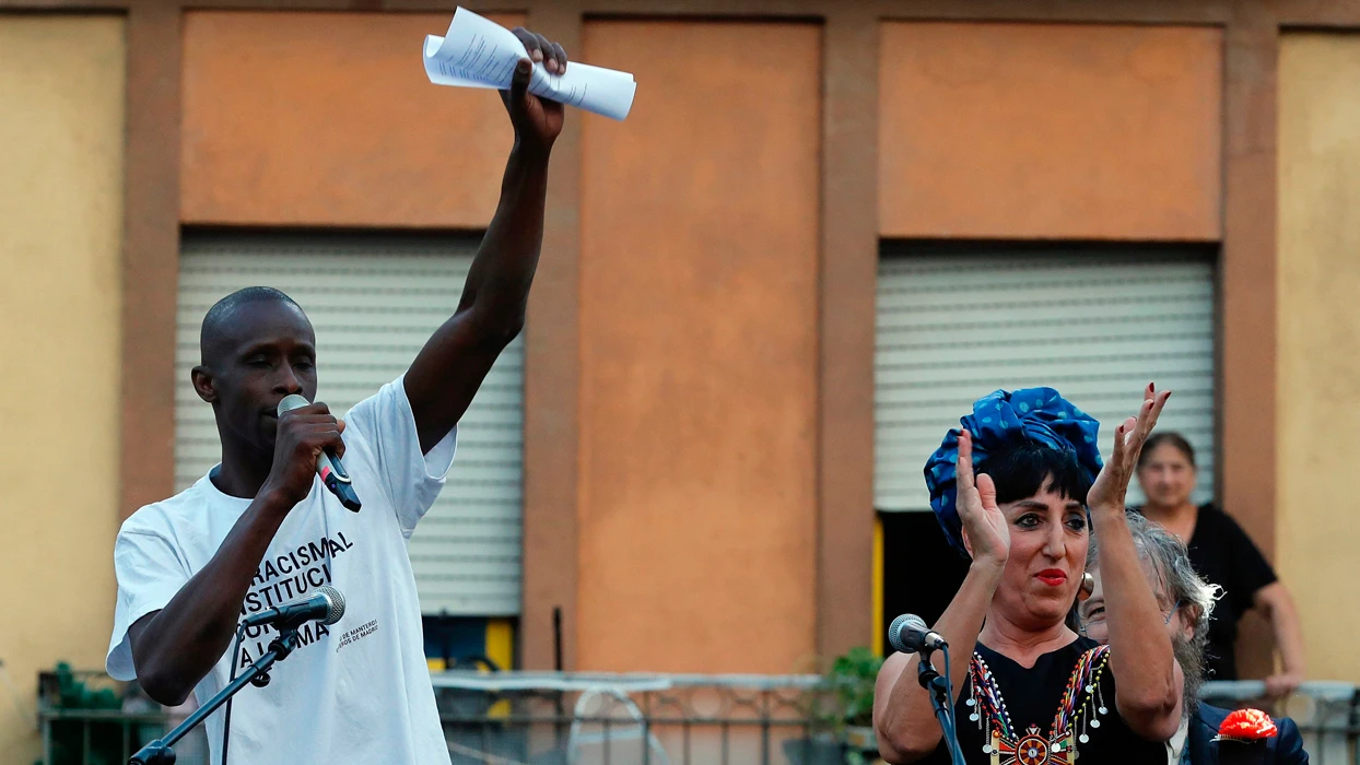 La actriz Rossy de Palma, y el representante del Sindicato de Manteros y Lateros, Serigne Mbaye Diouf, durante el tradicional pregón de las fiestas de San Lorenzo, esta noche en la plaza Nelson Mandela del barrio de Lavapiés en Madrid